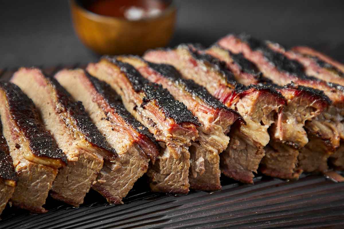 A close-up of sliced brisket with a dark, smoky bark.