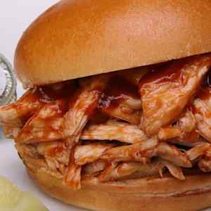 A close-up of a pulled chicken BBQ sandwich.