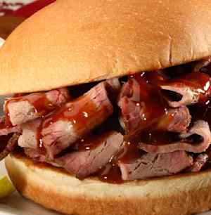 Close-up of a BBQ beef sandwich with sauce.